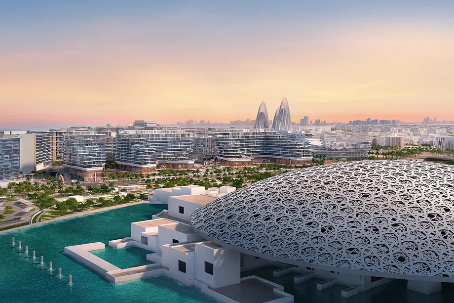 The perforated dome of the Louvre Abu Dhabi on the Saadiyat Island waterfront at dusk