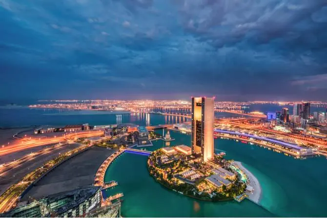 Bahrain Bay and the Manama skyline lit at dusk, seen from above