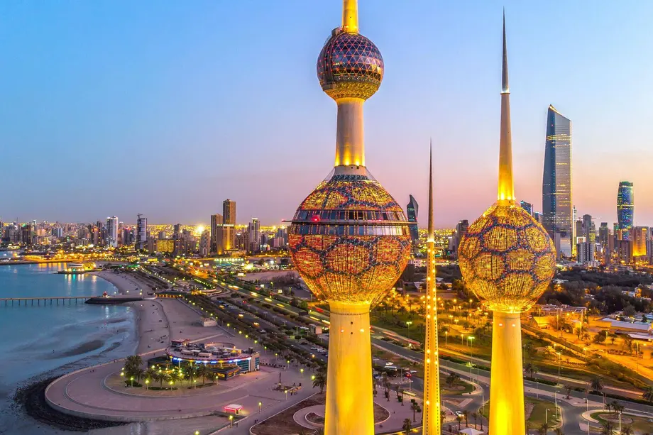 The Kuwait Towers lit at dusk, above the Gulf coast