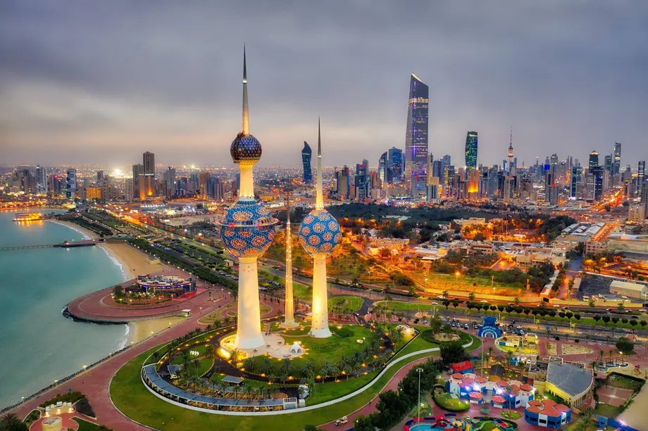 The Kuwait Towers lit at dusk, with Kuwait City behind them
