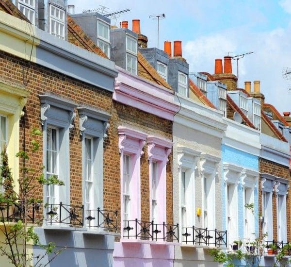 Pastel-painted period terraced houses on a UK residential street.